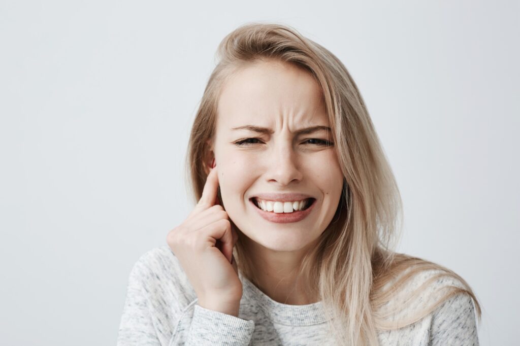 Masseter-Botox, eine junge Frau knirscht mit den Zähnen