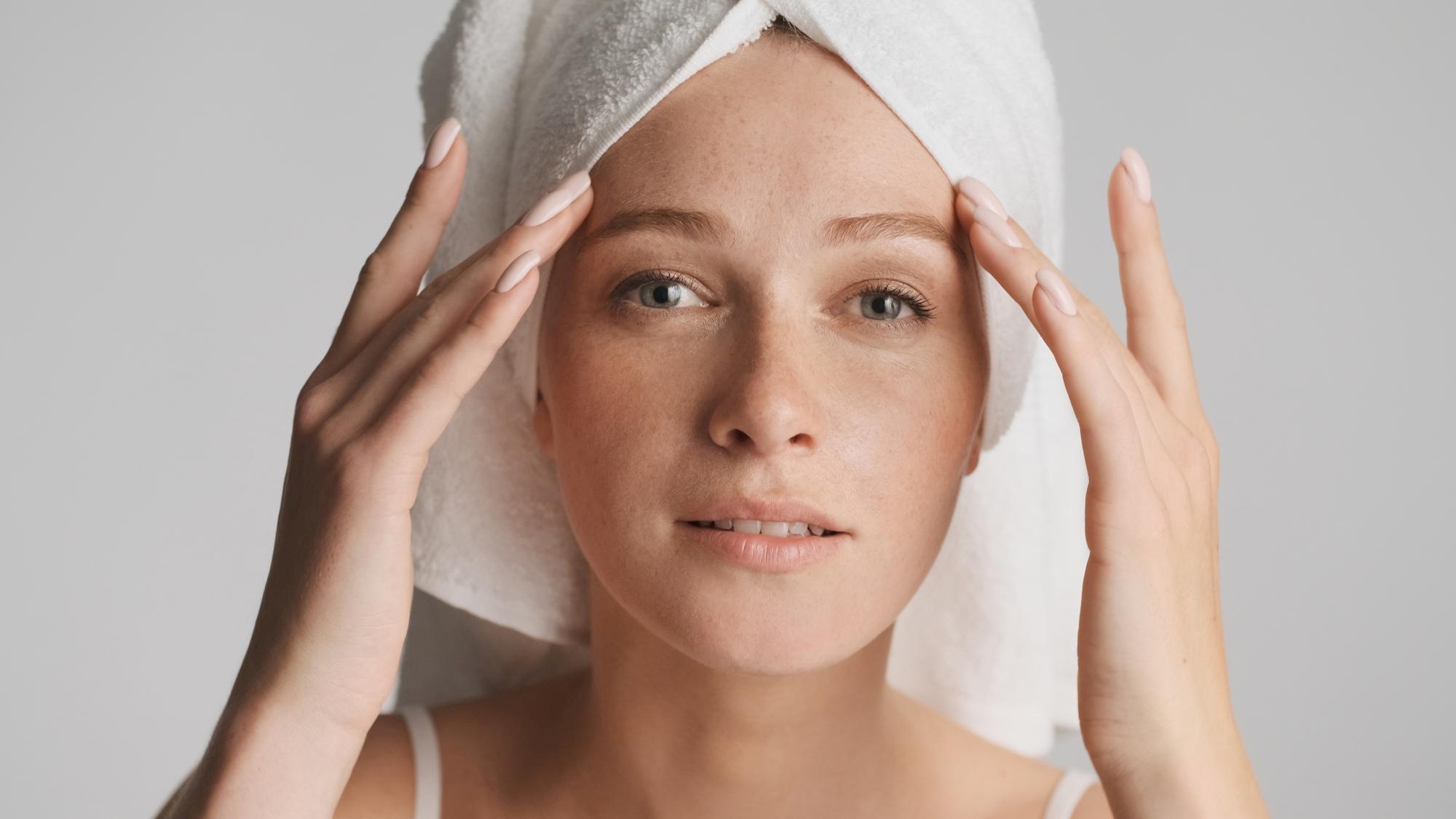 Epigenetik und Skin Longevity, eine Frau kontrolliert ihre Gesichtshaut auf Straffheit